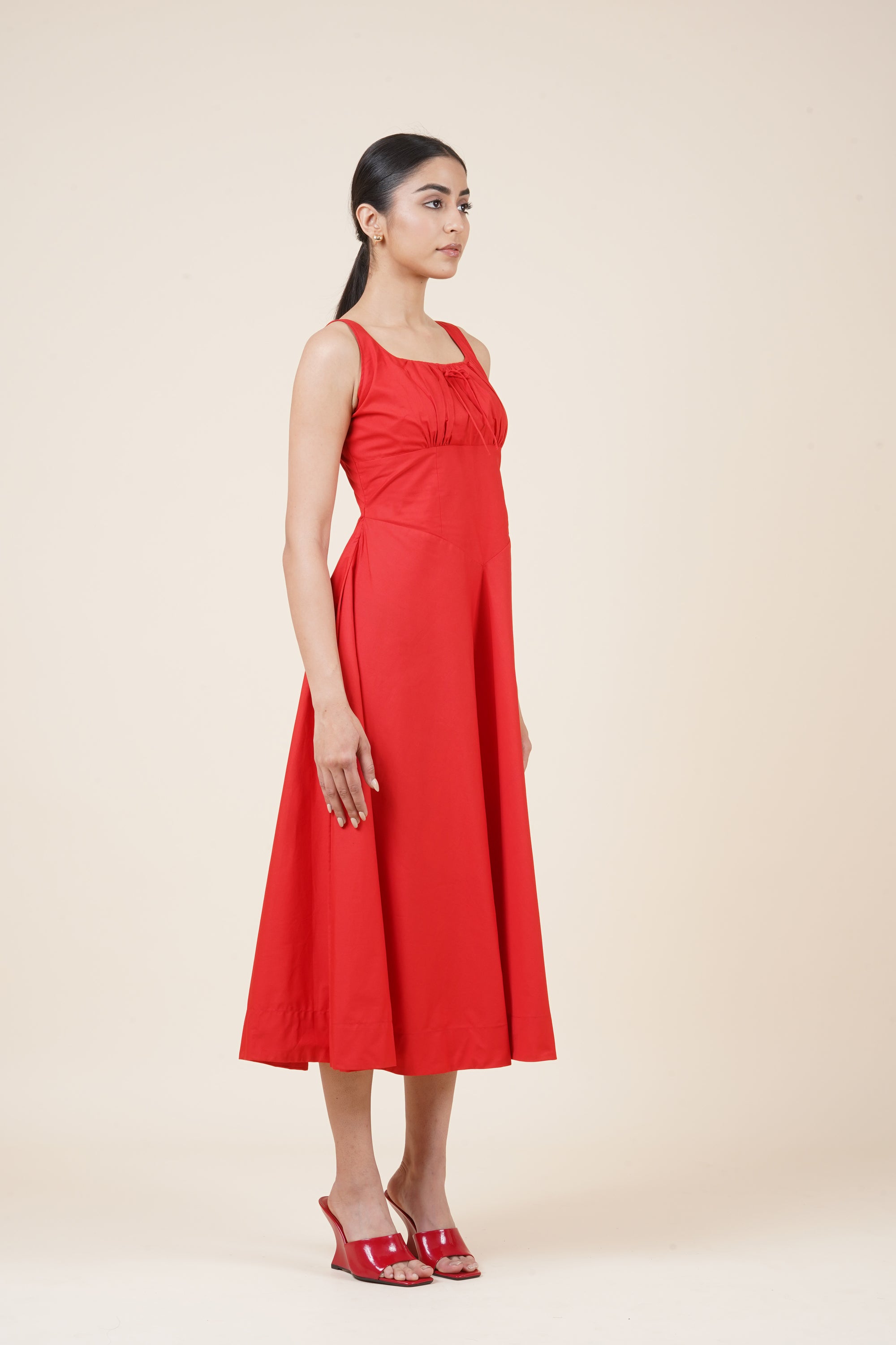 Woman wearing a red dress against a beige background